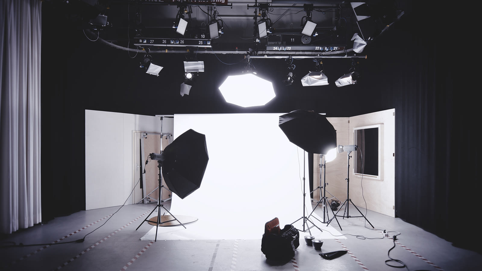 Film set with a camera on a tripod, a boom operator, and a producer watching a monitor.
