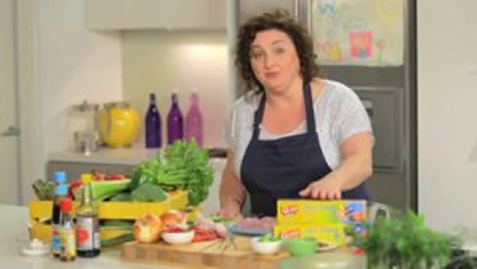 GLAD extra strong tie bags in a kitchen, with a person holding a bag.