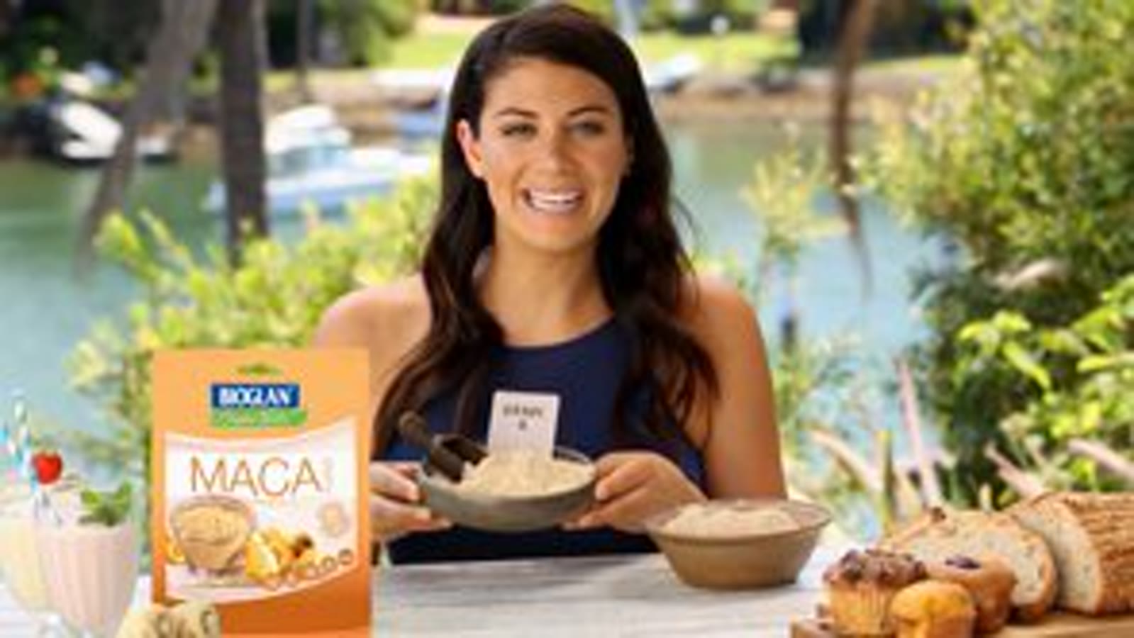 Bioglan Superfoods maca powder pack on a wooden board with a spoon of powder.